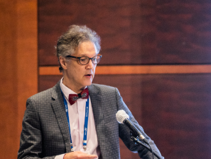 Person speaking into a microphone at a conference