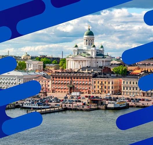 Waterfront view of Helsinki featuring Helsinki Cathedral and colorful harbor buildings under a partly cloudy sky
